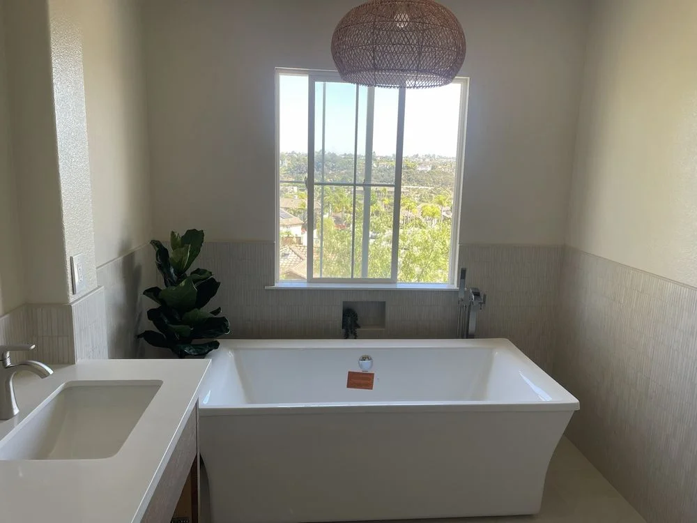 A newly installed walk-in shower with tile surround and frameless glass enclosure in an Encinitas, California home. The finished bathroom shows clean grout lines, a recessed niche, and a curbless entry suited to a coastal property.